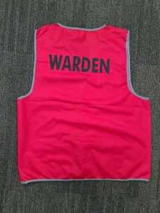 Red reflective safety vest for a Fire Warden, showing the back printed with "WARDEN" in black text.